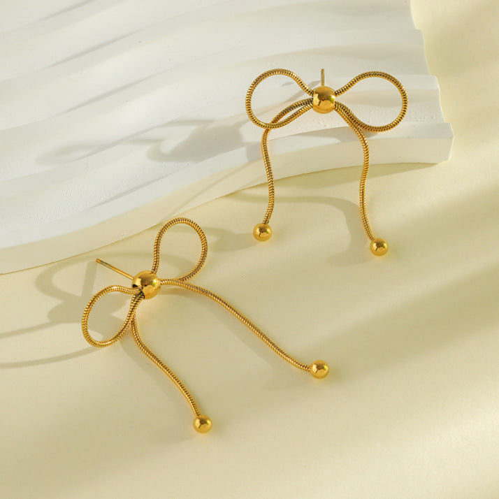 Baño de oro 18k.254 Aretes de moña con perlita dorada